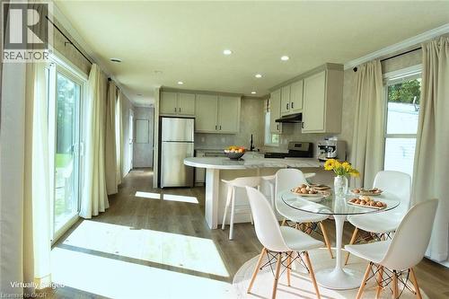 Kitchen featuring a peninsula, freestanding refrigerator, electric stove, light wood finished floors, and a breakfast bar area - 1085 Concession 10 Road W Unit# 23, Flamborough, ON - Indoor Photo Showing Dining Room