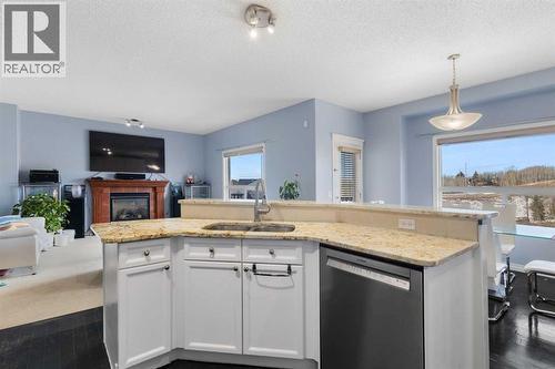 72 Rockyspring Circle Nw, Calgary, AB - Indoor Photo Showing Kitchen With Fireplace With Double Sink