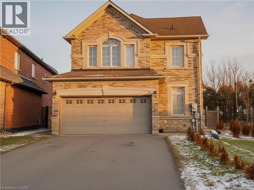 View of front of house featuring driveway, stone siding, a garage, and brick siding - 24 Hazelton Avenue, Hamilton, ON - Outdoor
