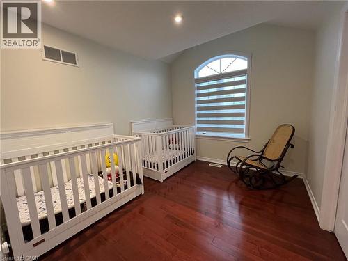 Bedroom featuring vaulted ceiling, dark wood-style flooring, a nursery area, and recessed lighting - 24 Hazelton Avenue, Hamilton, ON - Indoor