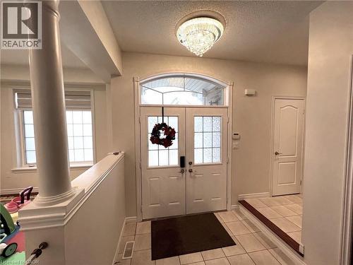 Foyer featuring light tile patterned floors, a textured ceiling, decorative columns, and french doors - 24 Hazelton Avenue, Hamilton, ON - Indoor Photo Showing Other Room