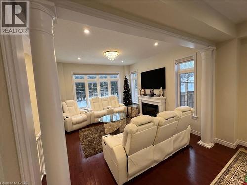 Living area featuring ornate columns, dark wood-style flooring, a glass covered fireplace, and recessed lighting - 24 Hazelton Avenue, Hamilton, ON - Indoor With Fireplace