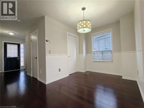 Unfurnished dining area featuring healthy amount of natural light and dark wood-style floors - 563 Dansbury Drive, Waterloo, ON 