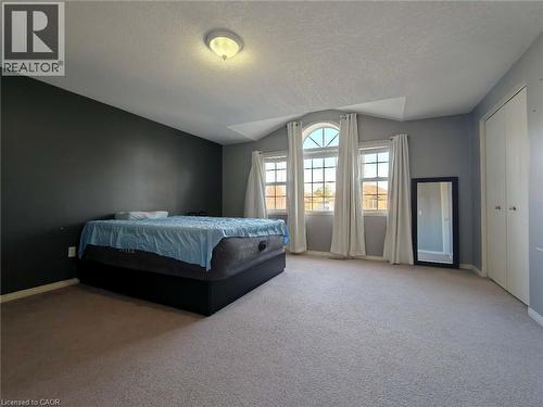 Carpeted bedroom featuring a textured ceiling and vaulted ceiling - 563 Dansbury Drive, Waterloo, ON 