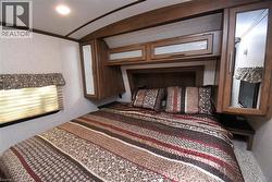 Carpeted bedroom with ornamental molding, lofted ceiling, and a textured wall - 