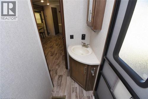 Half bathroom featuring light wood finished floors, vanity, and a textured wall - 1085 10Th Concession Road W Unit# 29, Flamborough, ON - Indoor Photo Showing Bathroom