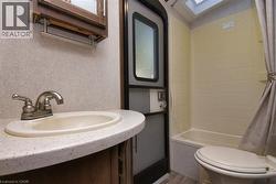 Bathroom featuring a skylight, vanity, and shower / bath combo with shower curtain - 