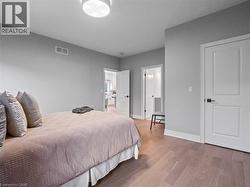 Bedroom featuring visible vents, baseboards, and wood finished floors - 