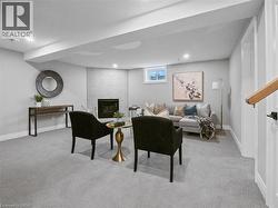 Carpeted living room featuring baseboards, recessed lighting, and a brick fireplace - 