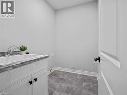 Washroom featuring baseboards, a sink, and cabinet space - 