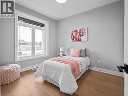 Bedroom featuring baseboards, multiple windows, and wood finished floors - 
