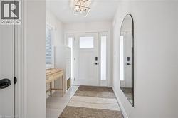 Foyer with plenty of natural light, a chandelier, and light wood-style floors - 