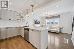 Kitchen with open floor plan, decorative light fixtures, open shelves, a peninsula, and backsplash - 