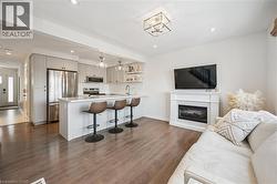 Living area with a glass covered fireplace, dark wood-type flooring, and recessed lighting - 