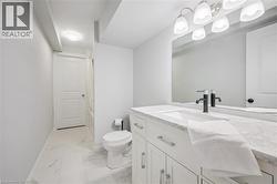Bathroom featuring vanity, shower / bathtub combination with curtain, and light marble finish floors - 