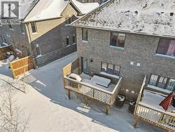 Snow covered house with brick siding and a patio area - 
