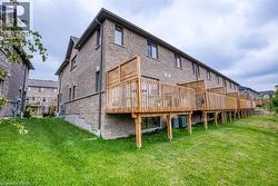 Rear view of property featuring a wooden deck and a yard - 