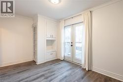 Main floor bedroom with double French doors leading to one of the backyard patios. - 