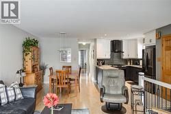 Living room with light wood-style floors and recessed lighting - 