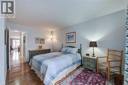 Bedroom with hardwood / wood-style flooring and baseboards - 