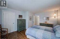 Bedroom featuring hardwood / wood-style floors and baseboards - 