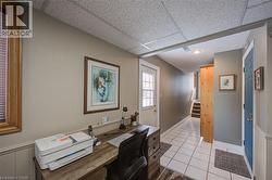 Office with a paneled ceiling and light tile patterned flooring - 