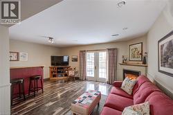 Living area featuring french doors, a glass covered fireplace, and dark wood-style flooring - 