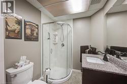 Bathroom featuring vanity, a paneled ceiling, and a marble finish shower - 
