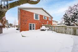 Snow covered rear of property with brick siding - 