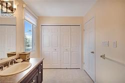 Bathroom with a closet, vanity, and light floors - 