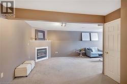 Unfurnished living room featuring carpet flooring and a glass covered fireplace - 