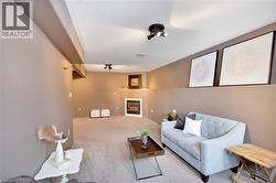 Carpeted living room with a textured ceiling and a glass covered fireplace - 