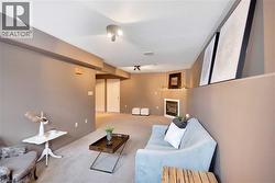 Living room with carpet floors, a textured ceiling, and a glass covered fireplace - 