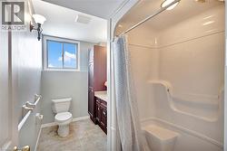Bathroom featuring curtained shower, vanity, and light tile patterned floors - 