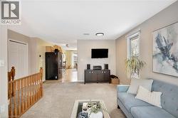 Living room with healthy amount of natural light and light colored carpet - 