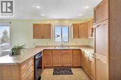 Kitchen featuring dishwashing machine, light countertops, recessed lighting, and a peninsula - 