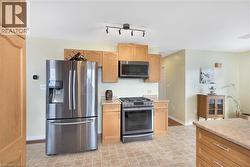 Kitchen with stainless steel appliances and light countertops - 