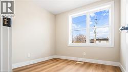 Spare room featuring light wood-style floors and baseboards - 