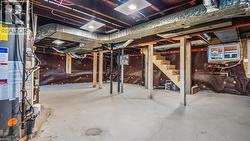 Unfinished below grade area with stairs and heating unit - 