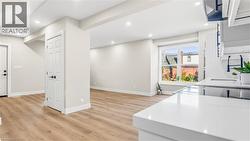 Kitchen with light wood finished floors, recessed lighting, and light stone counters - 