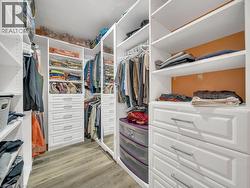 Walk in closet with light wood-style flooring - 