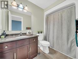 Bathroom with vanity, a shower with shower curtain, and light tile patterned floors - 