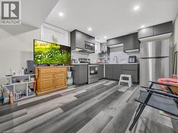 Kitchen with stainless steel appliances, tasteful backsplash, gray cabinets, open shelves, and light wood-style floors - 