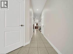 Hall with light tile patterned flooring and recessed lighting - 