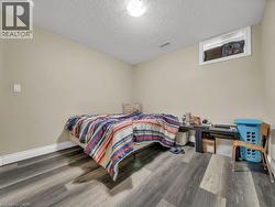 Bedroom with a textured ceiling and wood finished floors - 