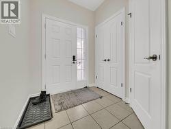 Foyer with light tile patterned floors and baseboards - 