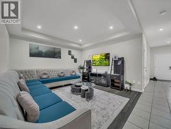 Living room with a raised ceiling, recessed lighting, and wood finished floors - 