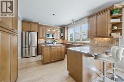 Large Kitchen with granite countertops, under-cabinet lighting, breakfast bar and island with plenty of storage space. Garage entry to the left - 