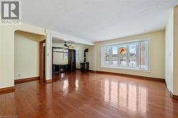 Unfurnished living room with light wood finished floors, a wood stove, and ceiling fan - 