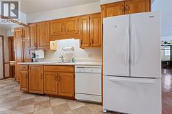 Kitchen featuring white appliances, light countertops, and brown cabinetry - 